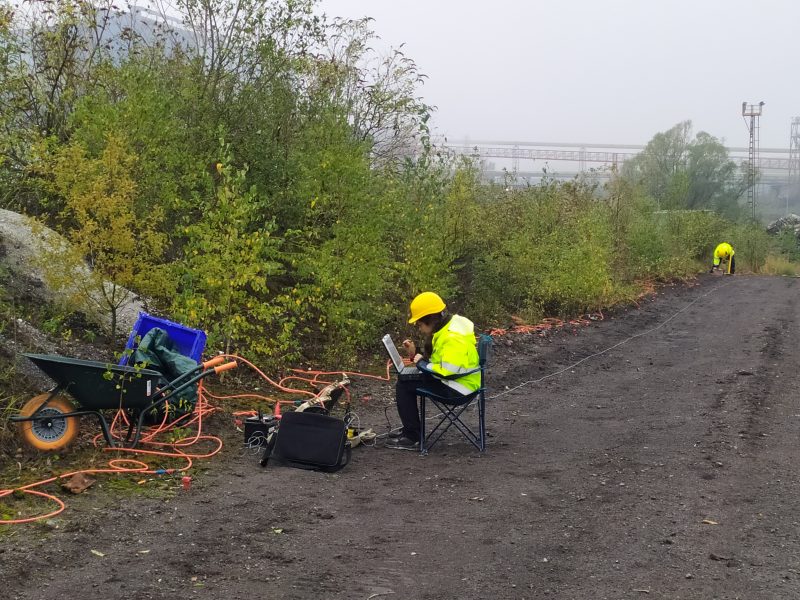 Prospectie van de bodem door medewerker in veiligheidskledij