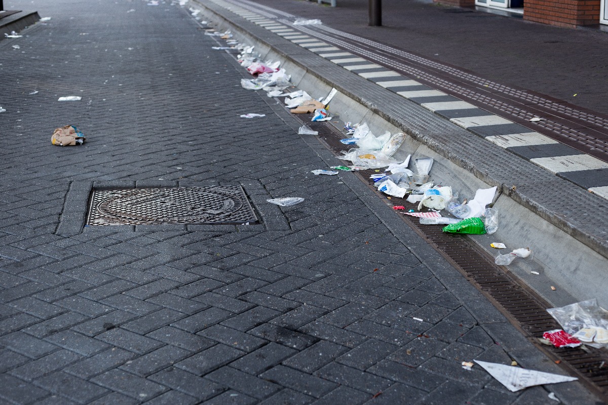 Weg en voetpad vol met vuilnis. Vuile straat na een festival.