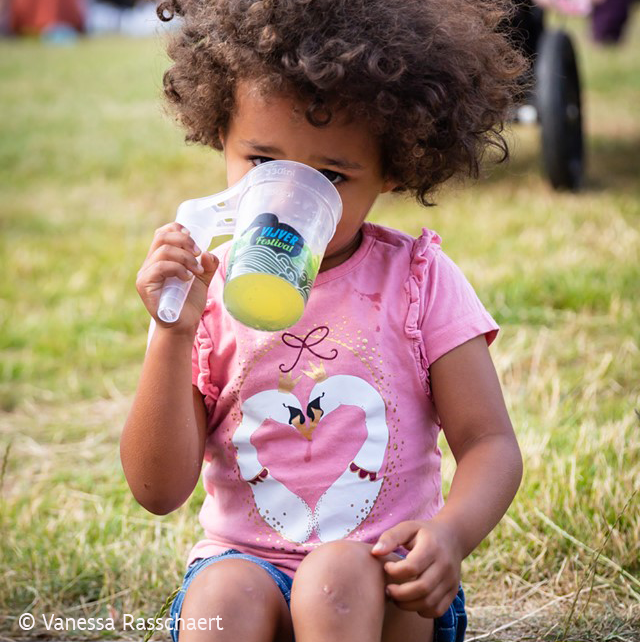 Kind drinkt van herbruikbare beker op festival